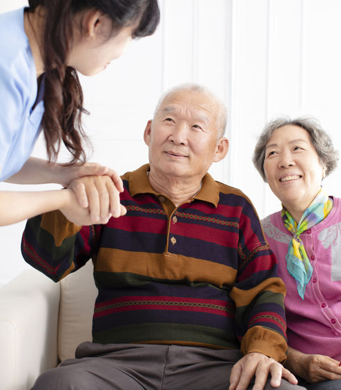 Health visitor and senior couple during home visit