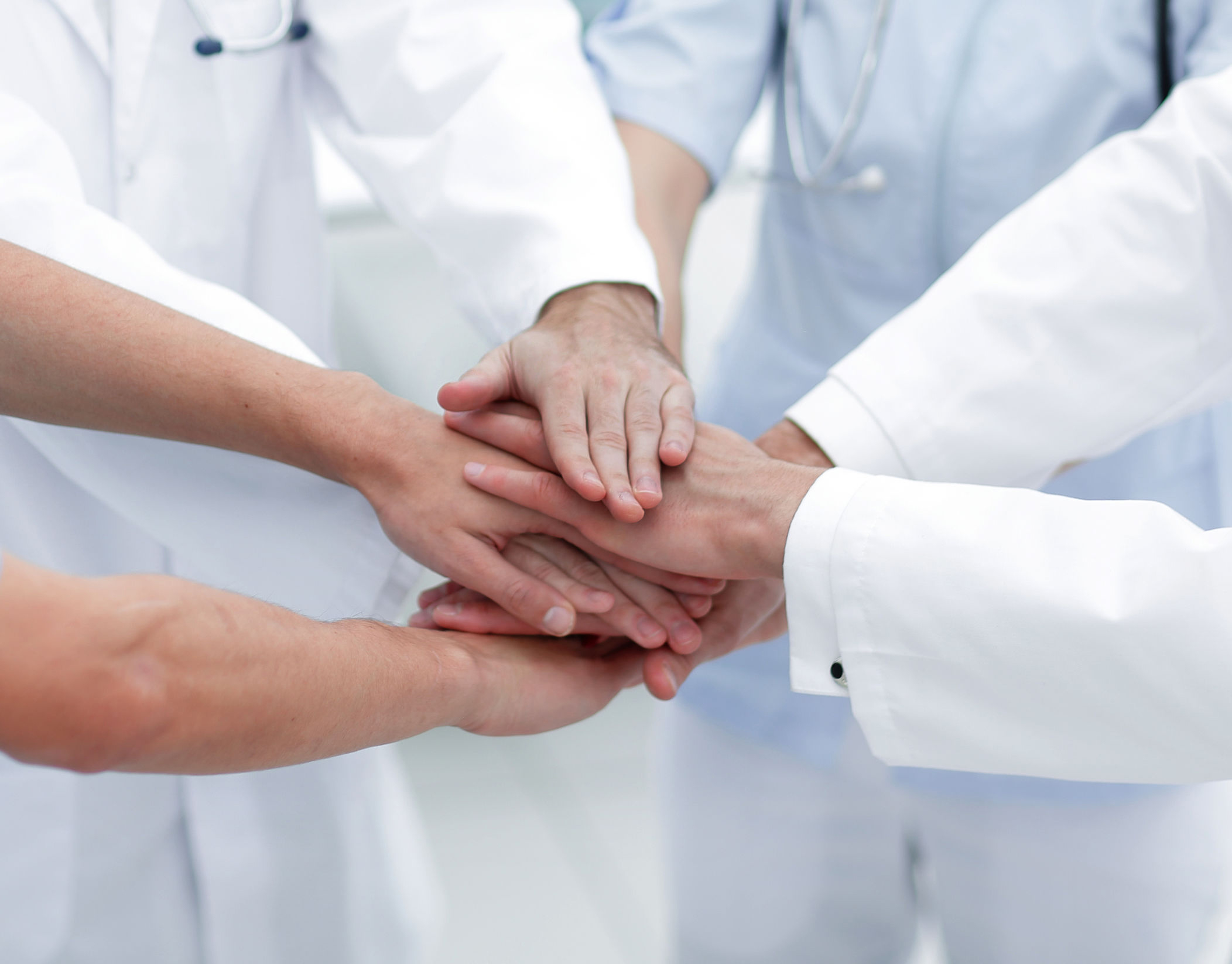 doctors holding hands together at hospital